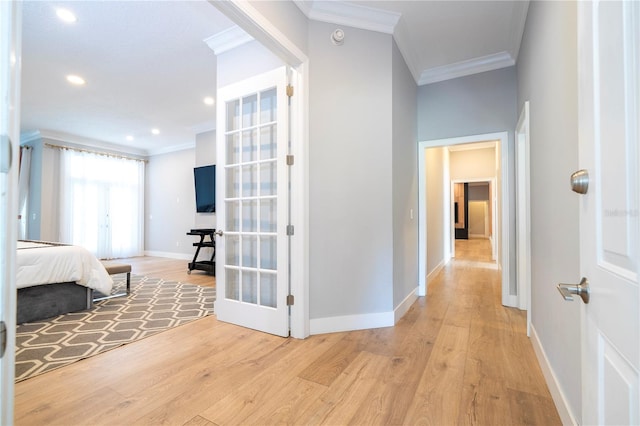 hall with crown molding, light hardwood / wood-style flooring, and french doors