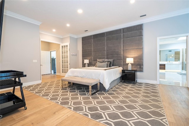 bedroom featuring hardwood / wood-style floors, ensuite bathroom, tile walls, and crown molding