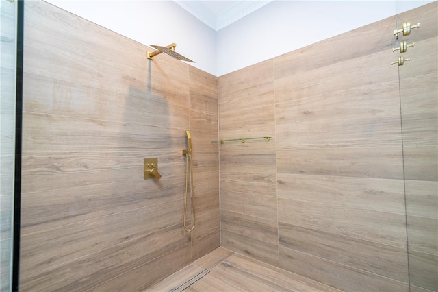 bathroom with crown molding and tiled shower