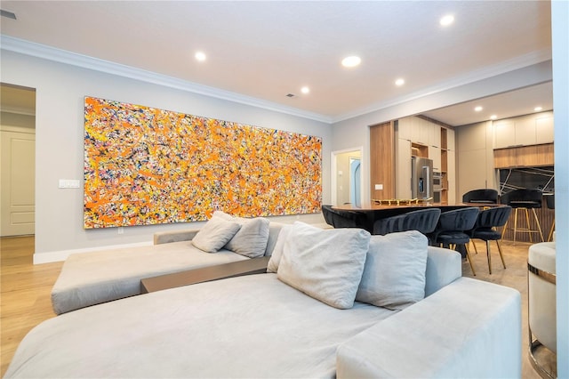 living room featuring crown molding and light hardwood / wood-style flooring