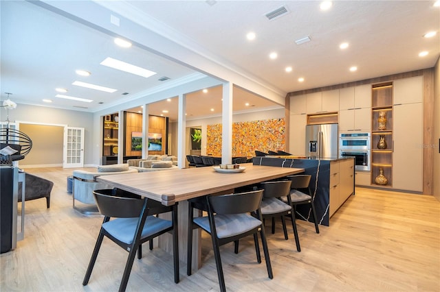 dining space featuring french doors, light hardwood / wood-style floors, and crown molding