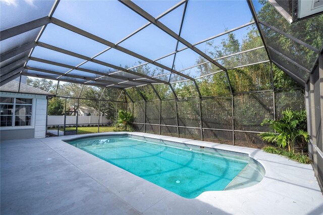 view of swimming pool with glass enclosure and a patio