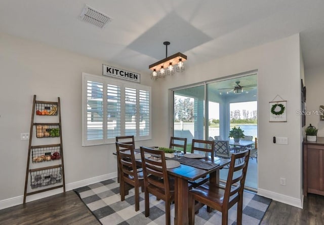 dining area featuring ceiling fan with notable chandelier and dark hardwood / wood-style floors