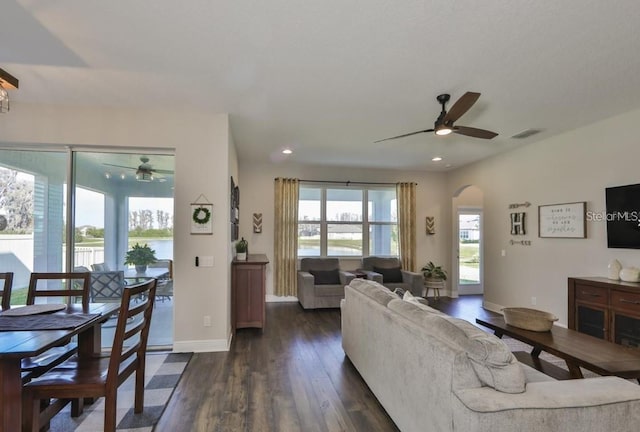 living room with dark wood-type flooring and ceiling fan