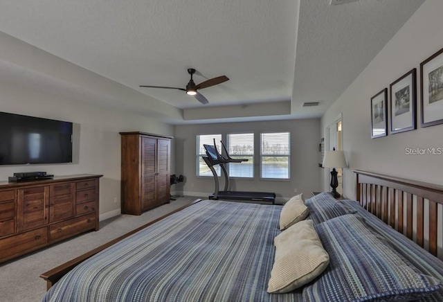 bedroom with a textured ceiling, light colored carpet, and ceiling fan