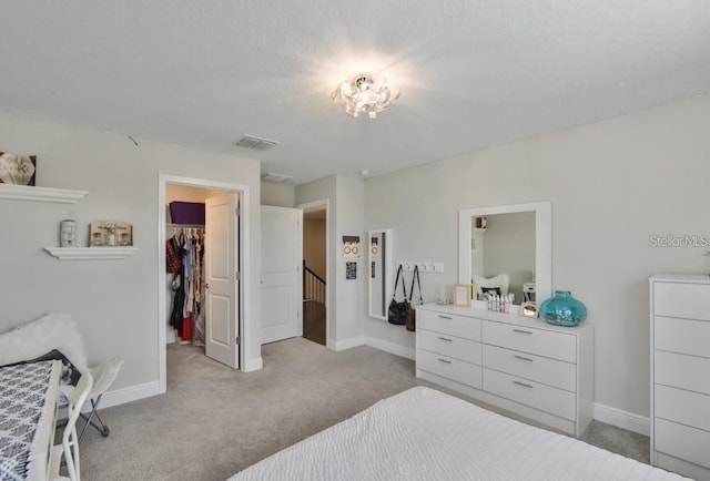 carpeted bedroom with a closet and a spacious closet