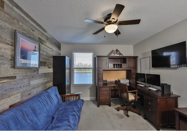 carpeted office featuring a textured ceiling and ceiling fan