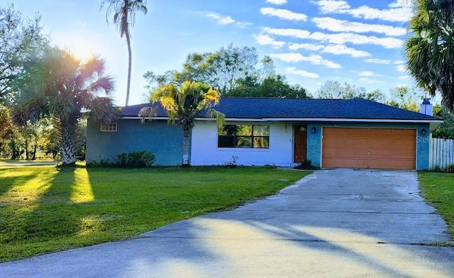 ranch-style home with a garage and a front lawn