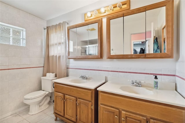 bathroom with tile patterned floors, toilet, tile walls, and vanity