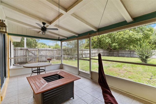 sunroom / solarium featuring lofted ceiling with beams and ceiling fan