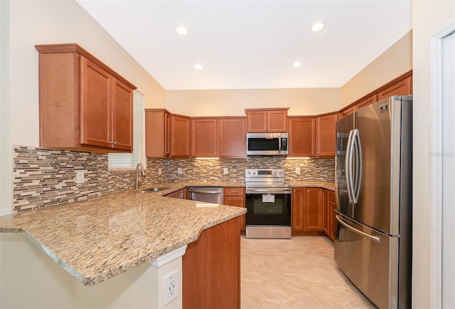 kitchen with sink, light stone counters, backsplash, kitchen peninsula, and appliances with stainless steel finishes