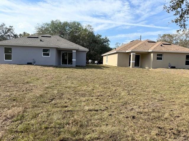 rear view of property featuring a yard