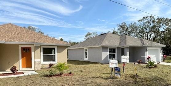 view of front of house featuring a garage and a front lawn