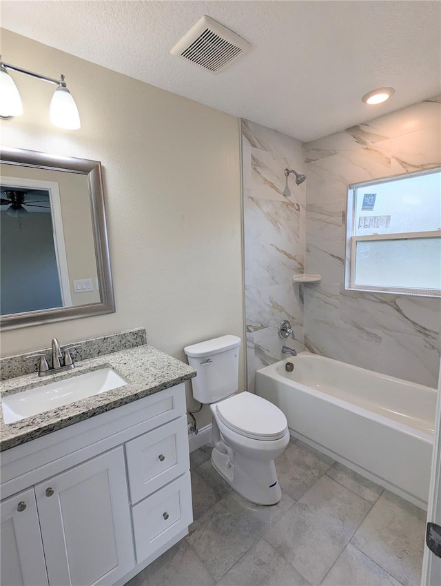 full bathroom with vanity, toilet, a textured ceiling, and tiled shower / bath