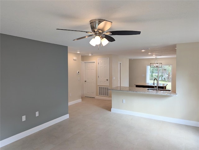 interior space with ceiling fan with notable chandelier and sink