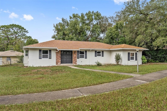 single story home featuring a front lawn and a garage