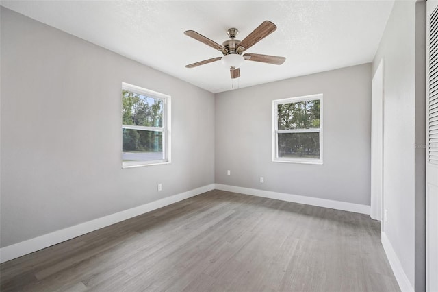 unfurnished room with light hardwood / wood-style floors, ceiling fan, a healthy amount of sunlight, and a textured ceiling