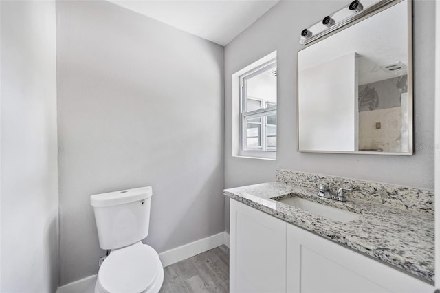 bathroom featuring toilet, vanity, and hardwood / wood-style floors