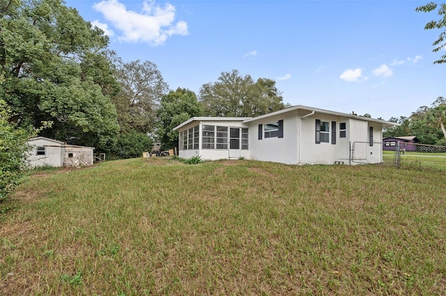 back of house featuring a yard and an outdoor structure