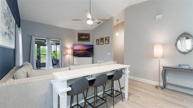 living room with light wood-type flooring, ceiling fan, and lofted ceiling