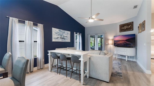 living room featuring ceiling fan, light hardwood / wood-style flooring, and high vaulted ceiling