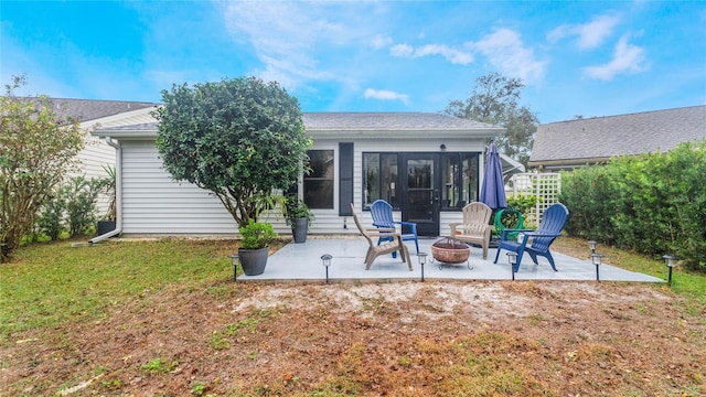 back of property featuring a patio area, a yard, and a fire pit