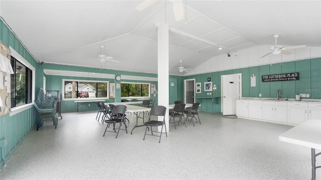 dining area featuring lofted ceiling and sink