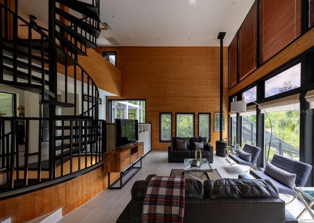 living area with a high ceiling and wood walls