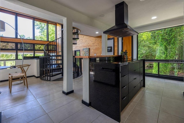 kitchen featuring island exhaust hood, recessed lighting, wood walls, black electric cooktop, and dark cabinets