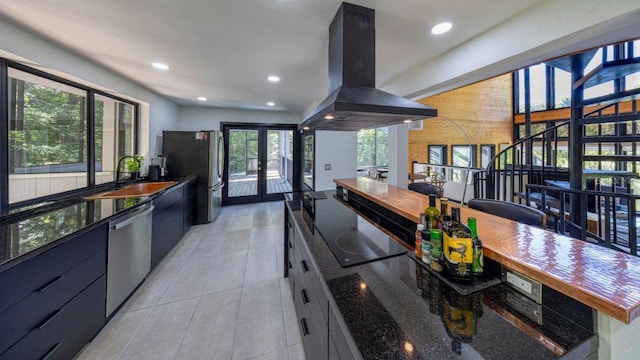 kitchen featuring french doors, stainless steel appliances, dark stone counters, and island range hood