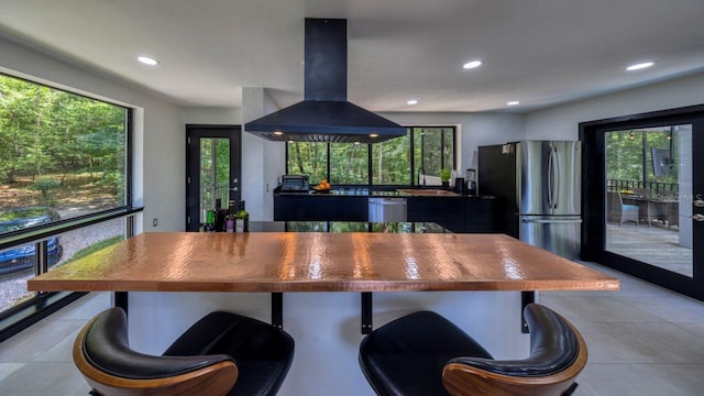 kitchen featuring island exhaust hood, plenty of natural light, recessed lighting, appliances with stainless steel finishes, and light tile patterned floors