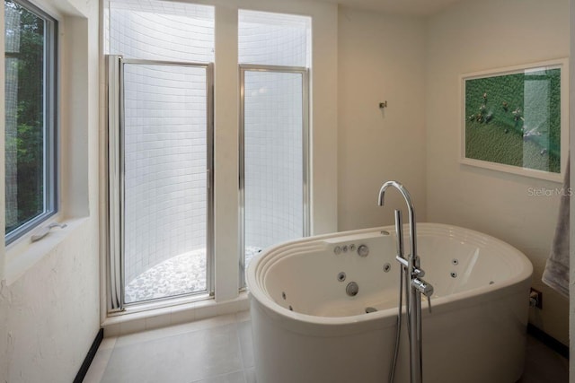 full bath with tile patterned floors, a stall shower, and a freestanding tub