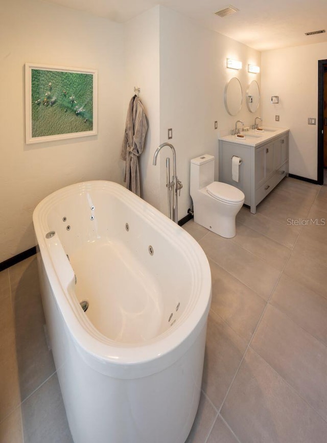 full bathroom featuring a tub with jets, visible vents, a sink, tile patterned flooring, and toilet