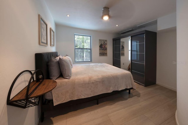 bedroom with light wood finished floors, visible vents, recessed lighting, and baseboards