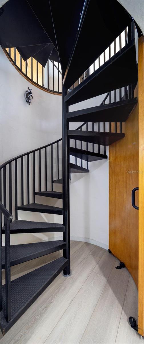 stairs featuring wood finished floors and baseboards