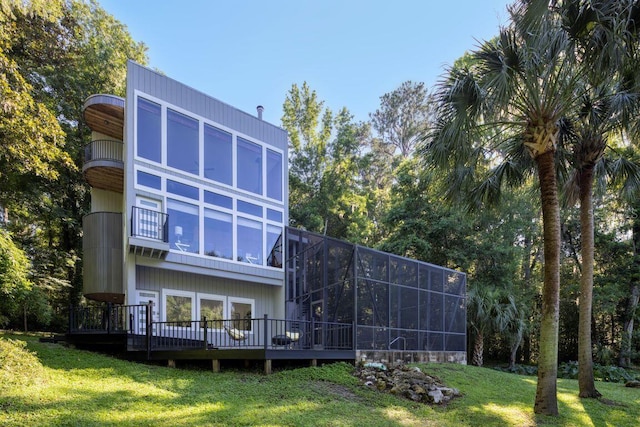 back of house featuring a lanai, a lawn, and a balcony