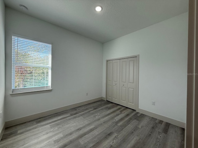 unfurnished bedroom featuring light hardwood / wood-style flooring and a closet