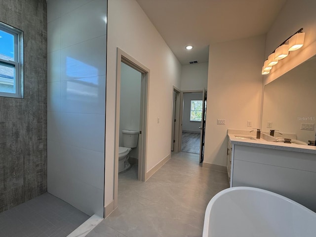 bathroom featuring a tub to relax in, tile patterned floors, vanity, and toilet