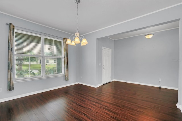 spare room featuring dark hardwood / wood-style floors, an inviting chandelier, and ornamental molding