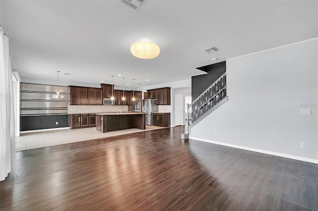 unfurnished living room with light hardwood / wood-style floors and a textured ceiling