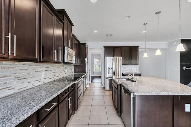 kitchen with backsplash, sink, an island with sink, decorative light fixtures, and stainless steel appliances