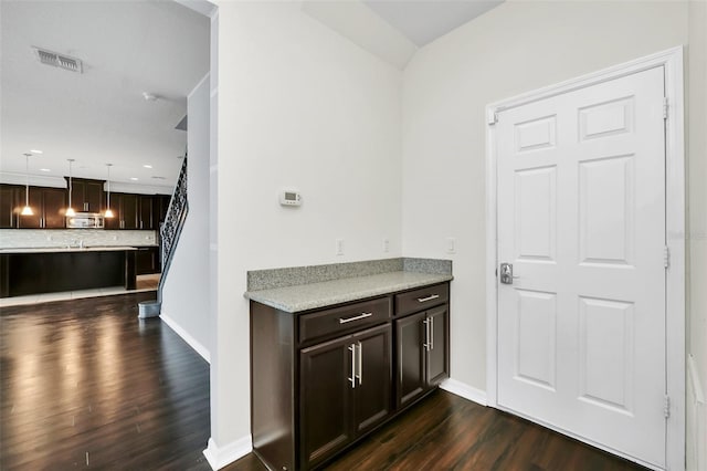 interior space featuring dark brown cabinetry, decorative backsplash, dark hardwood / wood-style floors, and decorative light fixtures