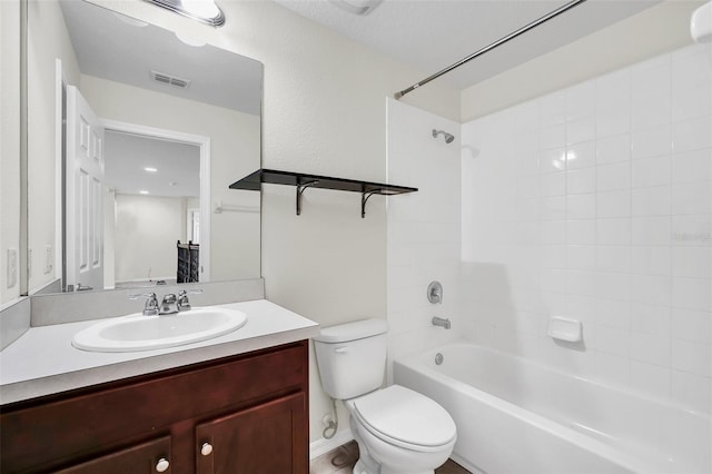 full bathroom with vanity, tiled shower / bath combo, and toilet