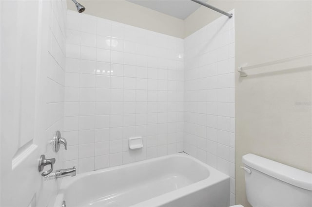 bathroom featuring tiled shower / bath combo and toilet