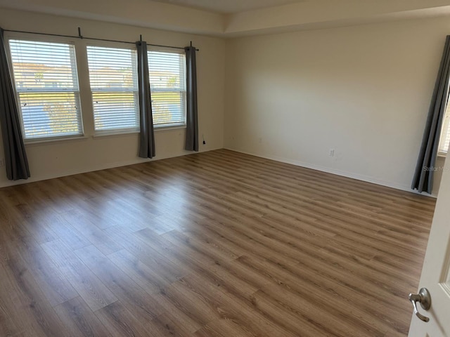 unfurnished room featuring plenty of natural light and dark wood-type flooring