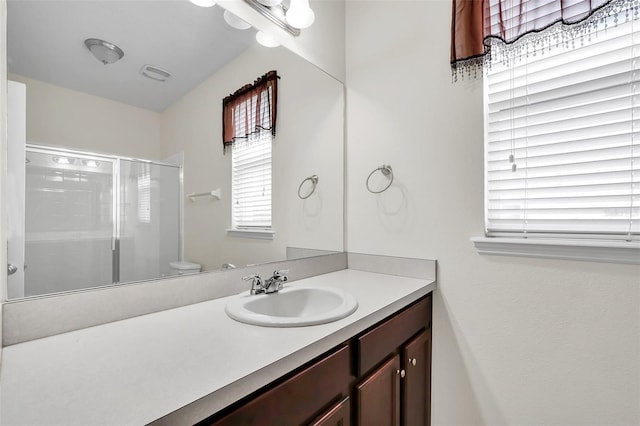 bathroom with vanity, an enclosed shower, and toilet