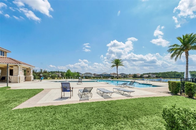 view of swimming pool featuring a lawn and a patio