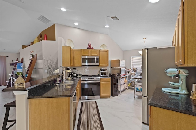 kitchen with a kitchen bar, lofted ceiling, sink, pendant lighting, and appliances with stainless steel finishes