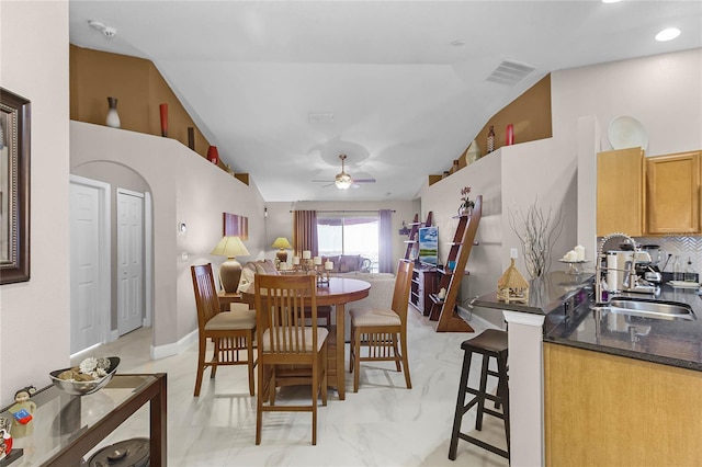 dining room with lofted ceiling, ceiling fan, and sink