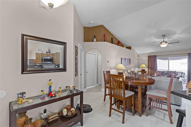 dining room with high vaulted ceiling and ceiling fan